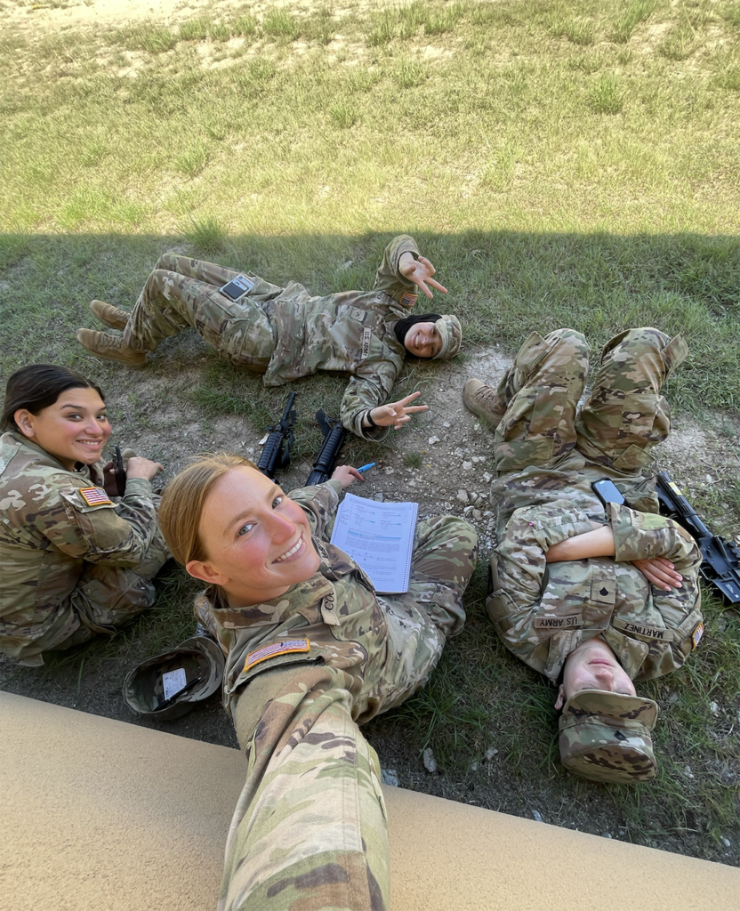 Four young people laying in grass studying